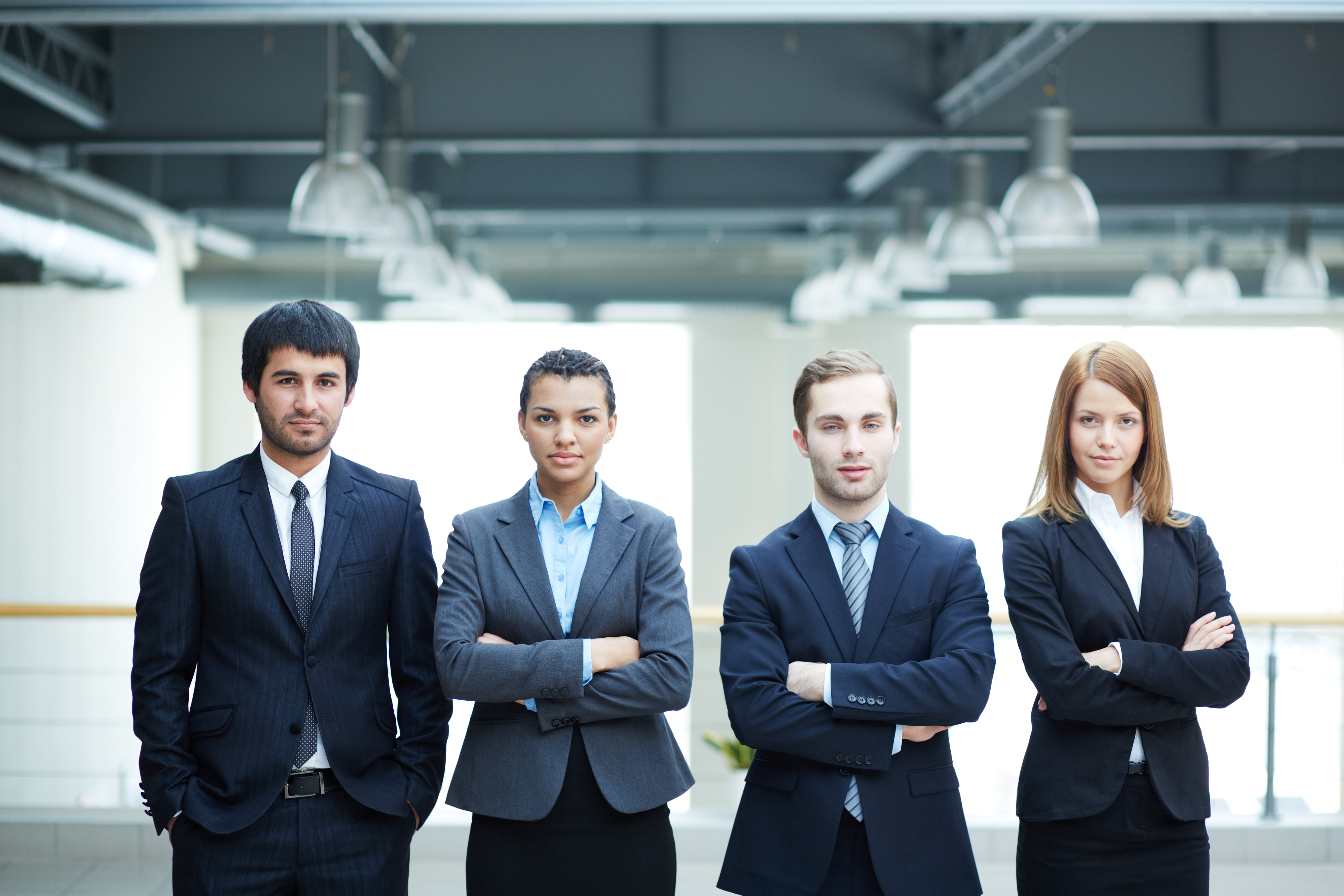 successful businesspeople with arms crossed in office